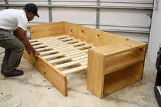 a man working on a bed frame in a garage