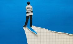 a man standing on top of a piece of paper in the shape of a mountain