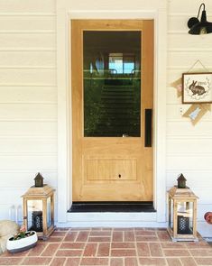 the front door to a house with two lanterns