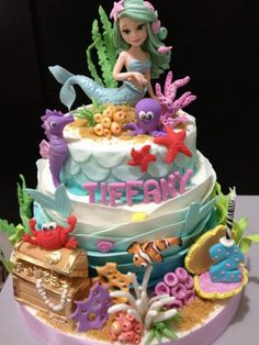 there is a cake decorated with an image of a mermaid and other sea creatures on it