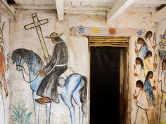 a painting on the side of a building depicting jesus riding a horse and holding a cross