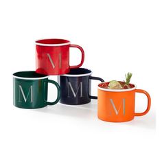 three different colored mugs with the letter m on them and one holding a drink