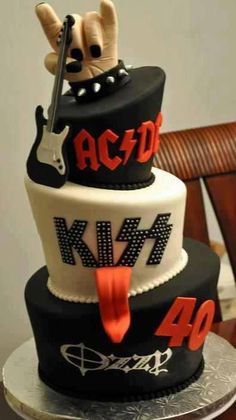 a three tiered cake decorated with guitars and the words ac / dc on it