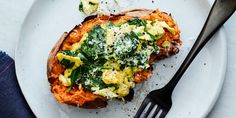 a white plate topped with an open face sandwich and a fork on top of it