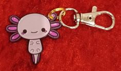 a keychain with a cartoon character on it sitting on top of a red blanket