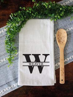 a wooden spoon sitting on top of a table next to a tea towel