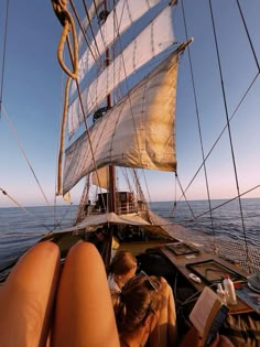 two people sitting on the back of a boat looking at something in the water while another person is reading