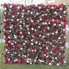 an artificial flower wall in the shape of a square with red and white flowers on it