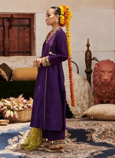 A striking ensemble, this purple raw silk sharara set showcases exquisite mirror work on the neckline and sleeves of the tunic, exuding elegance and charm. Paired with matching pants and a contrasting lime green organza dupatta, this outfit beautifully balances richness and vibrancy, making it a perfect choice for festive celebrations and special events. Raw Silk Sharara, Silk Sharara, Straight Suit, Beach Wedding Guests, Jacket Cape, Ritu Kumar, Set Saree, Sharara Set, Organza Dupatta