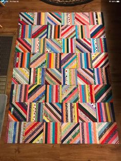 a colorful quilt sitting on top of a wooden floor