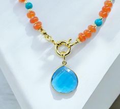 Awaken your inner strength with this radiant necklace, designed to inspire and uplift. Featuring AAA+ natural Carnelian rondelle beads, known for igniting courage and passion, paired with the protective and calming energy of turquoise, this piece is a true talisman.  The London Blue Quartz pendant, set in gold vermeil, adds a touch of elegance while enhancing emotional clarity. Perfectly suited for Aries, Leo, Sagittarius, and Pisces, this necklace is your go-to for channeling strength and seren Blue Carnelian Jewelry As A Gift, Spiritual Blue Carnelian Jewelry, Blue Carnelian Jewelry For Gifting, Blue Carnelian Spiritual Jewelry, Blue Carnelian Jewelry For Gift, Blue Carnelian Jewelry Gift, Talisman Jewelry, Mystical Jewelry, Aries Leo