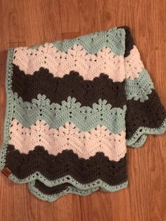 two crocheted afghans sitting on top of a wooden floor