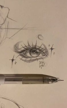 a pen is next to a drawing of an eye