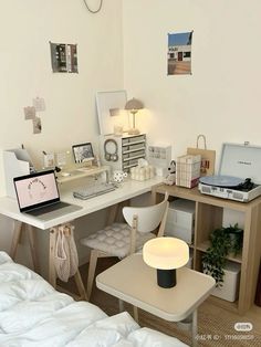 a white desk with a laptop computer sitting on top of it next to a bed