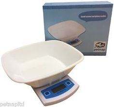 a white bowl sitting on top of a scale next to a box with the lid open