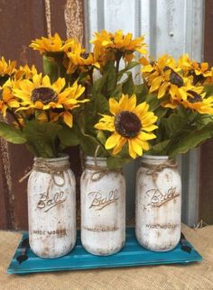 three mason jars with sunflowers in them