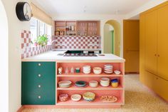 a colorful kitchen with lots of plates and bowls on the counter