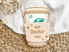 a wooden magnet with the words best teacher ever on it and a cup of coffee