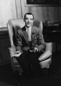 a man in a suit and tie sitting in a chair