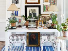 a white table topped with pictures and plants