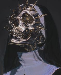 a skull with spikes on it's head is wearing a black veil and white shirt