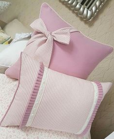 pink and white pillows with bows on them