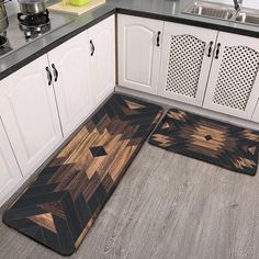 a kitchen with white cabinets and wood flooring on the counter top, next to an area rug