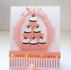 a card with cupcakes on it and a hand holding the card in front