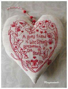 a white heart with red thread on it and words written in the center that says, a god friend is like spring becoming in the heart