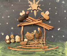 a nativity scene made out of sticks, rocks and twigs with a star above it