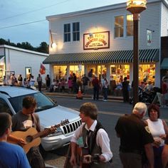 a group of people standing in front of a building with a guitar on the street