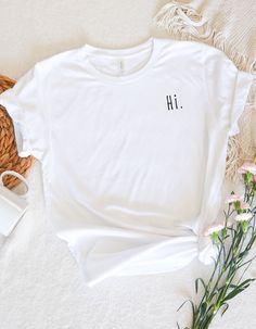 Bring lightness and style to your everyday life with our "Hi" statement T-shirt. This T-shirt offers you the perfect mix of comfort and style. Whether you wear it casually with jeans or use it as a statement piece for special occasions, this shirt is a real all-rounder. More than just a T-shirt: Simple message: The simple "Hi" makes it an unmistakable eye-catcher. High-quality printing: carefully crafted for long-lasting enjoyment. High-quality material: Made from combed and ring-spun cotton and Trendy Everyday Shirt With Letter Print, Simple Summer T-shirt With Letter Print, Minimalist Short Sleeve Letter Print T-shirt, Trendy T-shirt With Funny Text For Everyday, Everyday Crew Neck Shirt With Funny Print, Everyday Funny Print Crew Neck Shirt, Summer Shirt With Text Print For Everyday, Trendy Everyday T-shirt With Funny Text, Everyday Summer Shirt With Slogan