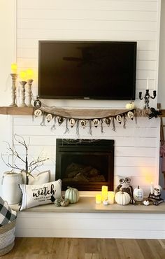 a living room decorated for halloween with candles and decorations on the fireplace mantels