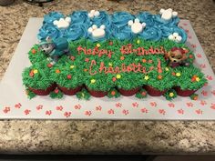 a birthday cake that is decorated with cupcakes and frosting