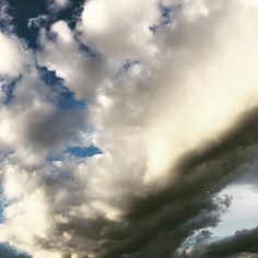 the sky is full of clouds and some buildings