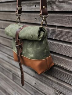 This day bag / satchel is your perfect companion for the days when you only need some necessities to take with you. The day bag is made in heavy weight waxed  canvas in color olive green, with roll to close top, with snap and strap closing. Made it with a brown leather bottom, for extra durability and strength. Phone pocket on the backside closing with pouch button. With adjustable and detachable shoulder strap in vegetable tanned leather Fully lined with a cotton canvas  The size of this bag me Waxed Canvas Messenger Bag, Green Crossbody Satchel For Outdoor, Green Waxed Canvas Bag, Green Waxed Canvas Bags With Adjustable Strap, Green Waxed Canvas Backpack, Green Waxed Canvas Bag For Everyday Use, Green Canvas Crossbody Satchel, Waxed Canvas Satchel For Adventure, Khaki Adventure Bags With Waxed Finish