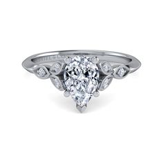 a pear shaped diamond engagement ring on a white background