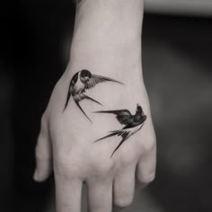 a hand with three birds on it and one bird flying away from the other wrist