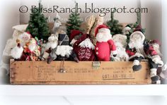 a wooden box filled with lots of santa clause figurines sitting on top of a shelf