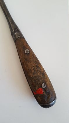 an old wooden baseball bat laying on top of a white table next to a wall