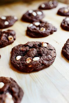 chocolate cookies with marshmallows are lined up on a cutting board and ready to be eaten