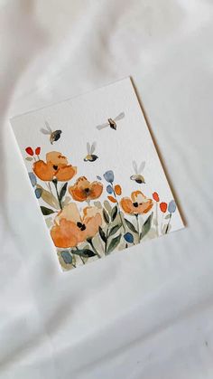 a card with watercolor flowers on it and bees flying over the flowered field