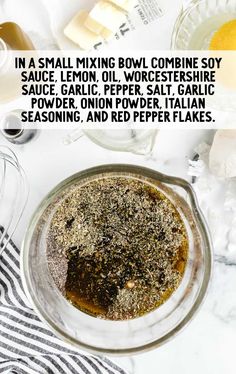 a bowl filled with spices and seasoning next to other ingredients on a white table