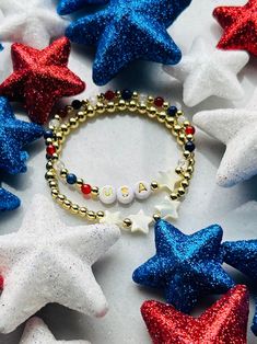 Show your patriotism with this festive USA bracelet. Perfect for Fourth of July, Memorial Day or any patriot loving event. Made with natural gemstones and 18k gold filled beads that are much more tarnish resistant and lasting opposed to the the more commonly seen gold plated. You will have this forever!  These bracelets layer well with others so add this to your stack! Sizing for girls and women. Beaded on high quality stretch cord and secured. - Choice of USA bracelet or set -  4mm 18k gold filled beads      4mm lapis stone (blue)    4mm quartz    4mm carnelian stone (red)    acrylic letters beads    mother of pearl stars     - If you would prefer different personalization other then "USA", please enter in personalization box - Each purchase is sent in a drawstring velvet jewelry bag, mak Patriotic American Flag Jewelry For Independence Day, American Flag Jewelry For Independence Day Gift, Patriotic American Flag Jewelry Gift, Patriotic Round Beads Jewelry Gift, Patriotic American Flag Jewelry For 4th Of July, American Flag Jewelry For 4th Of July Gift, American Flag Jewelry For 4th Of July, Patriotic Bracelets For 4th Of July Gift, American Flag Jewelry Gift For 4th Of July