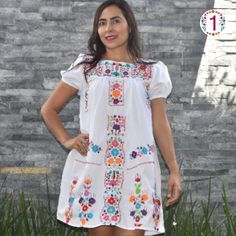 This lovely dress was handmade in Mexico. The beautiful colorful flowers were embroidered by hand, so each one is unique. You will love wearing this comfortable cotton dress with short sleeves. It is perfect for a hot summer day. This dress comes just above or below the knee, depending on how tall you are. It has a square neckline and cute little puffy sleeves.  The measurements on this dress are: Medium: 19-20" wide Large: 21"-22" wide XLarge: 23"-24" wide XXLarge: 25"-26" About Our Items: Each one of our items is handmade/hand woven by Indigenous communities of Chiapas and Oaxaca in Mexico. Great care has been taken to ensure the quality and uniqueness of each item we sell.  Our items are made of cotton. Each flower on each item will be a bit different as they were embroidered carefully Traditional Multicolor Floral Embroidery Dress, Multicolor Geometric Embroidery Dress For Festivals, Traditional Multicolor Embroidered Dress For Spring, Traditional Floral Embroidered Dress For Spring, Traditional Embroidered Floral Dress For Spring, Traditional Spring Floral Embroidered Dress, White Hippie Dress With Floral Print, Festival Dress With Multicolor Geometric Embroidery, Handmade Multicolor Dresses For Spring