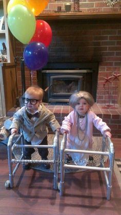 two children sitting in a baby walker with balloons