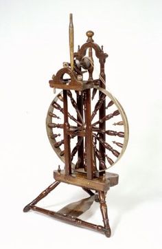 an old wooden spinning machine with wheels on it's sides and spokes in the center