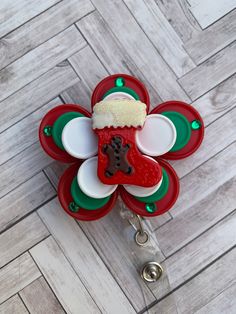 a red, green and white flower shaped object with a santa hat on it's head