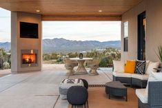 a living room with furniture and a fire place in the middle of it's patio