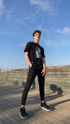 a young man is standing on a boardwalk